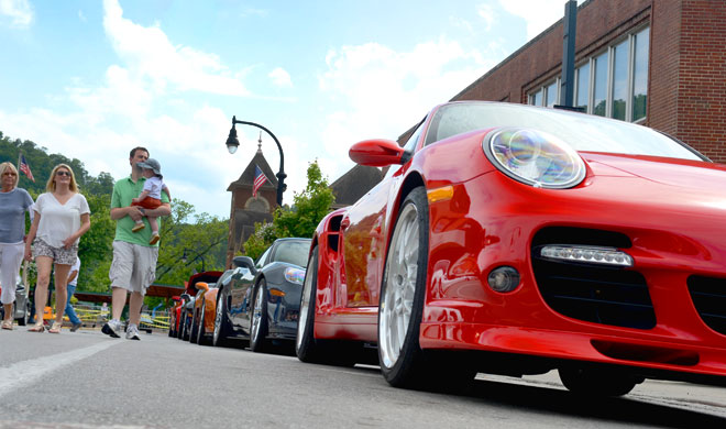 Cars lined up on a sidewalk with a family